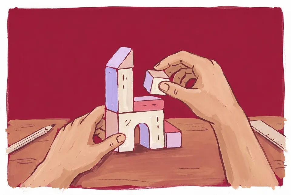 Hands stack paper and lavender toy blocks into a small tower on a cranberry ground